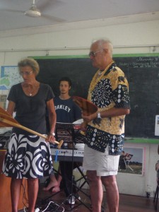 Derrick is showing the kids a sample of the 30+ paddles we brought to donate to their club.